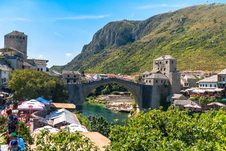 MOSTAR, BOSNIA - AUGUST 4, 2019 : View of Old Mostar Bridge on Neretva River with people. Mostar is one of the most famous place of Balkans.のeditorial素材