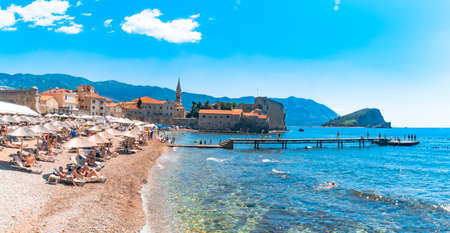 BUDVA, MONTENEGRO - AUGUST 5, 2019 : Old town Budva, Montenegro with people on beach, Budva has oldest settlements citadel ancient walls near Balkan mountains and Adriatic Sea.のeditorial素材