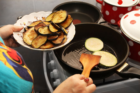 Hostess with the gas stove zharit zucchini with eggplant.