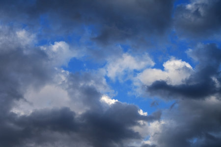Clouds against the blue sky. Plane in the sky.