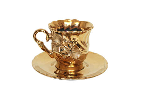 Teacups color of gold. Close-up. Isolated on white background.の写真素材