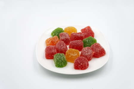 Multicolored marmalade on a white plate. On a white background.の写真素材