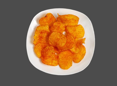 Potato chips on a white plate. Isolated on a gray background.の写真素材