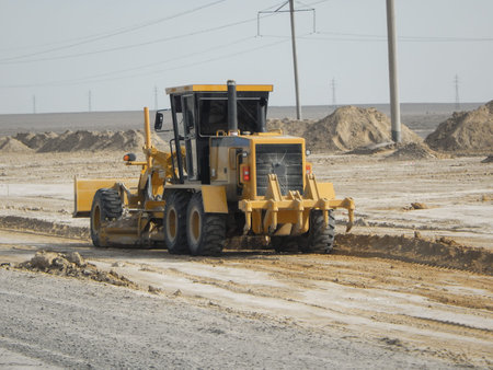 Road scraper in the steppe. Laying a new road in the desert.