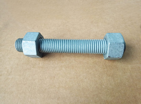 Bolt with nut. Close-up. On the background of cardboard packaging.