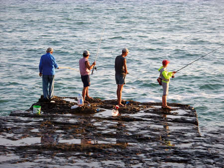 Fishermen on the rocky shore of the Caspian Sea. Kazakhstan. Aktau 10July 2019 year. Mangistau region.のeditorial素材