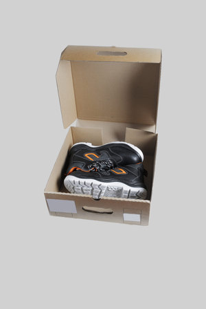 Safety shoes in a cardboard box. Close-up. On white background.