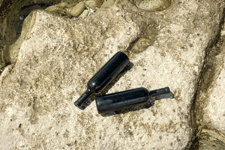 Two bottles of wine on the rocky shore of the Caspian Sea.の写真素材