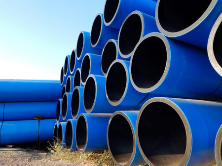 Industrial polymer pipes. Plastic pipes stacked on the ground.