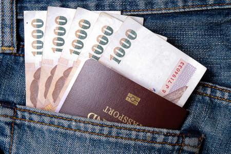 thai passport and money in back pocket of a blue jeansの写真素材