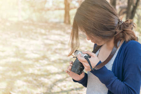Woman photographer enjoy with her camera in the park.の写真素材