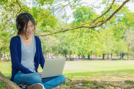 The woman working in the park with laptop.の写真素材