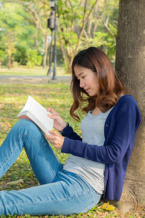 The woman reading book in the park.の写真素材