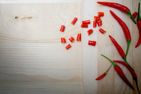 Sliced red chili pepper on wooden table.