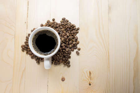 Coffee cup and beans on wooden table.の写真素材