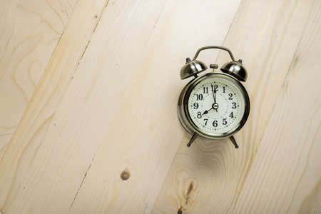 Retro alarm clock on wooden table. time conceptの写真素材