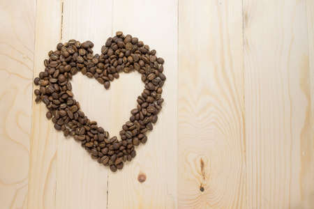 Coffee beans heart  shape on wooden table.の写真素材