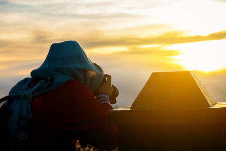 Back side of a photographer take a photo on the mountain.の写真素材