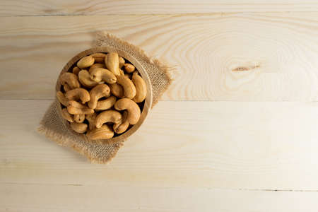 Cashew nuts in a bowl on wooden table.の写真素材
