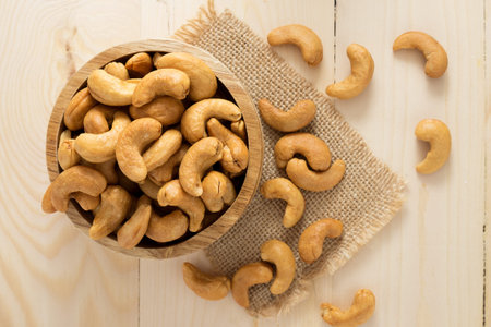 Cashew nuts in a bowl on wooden table.の写真素材