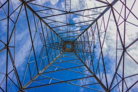 inside the electricity transmission pylon against blue sky. High voltage pylonの写真素材