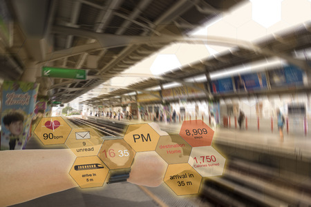 internet of things technology concepts the man use augmented reality watch to receive information or help his life so easy by search time, heart rate, steps, mail, train arrival at sky train stationの写真素材