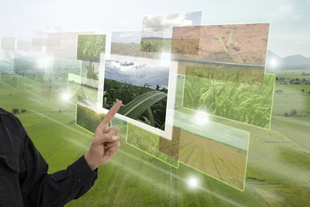 Internet of things(agriculture concept),smart farming,industrial agriculture.Farmer point hand to use augmented reality technology to control ,monitor and mangement in the farm