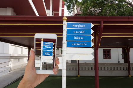 iot,internet of things,traveling concept, man  hold phone and use application of augmented reality technology to translate from local language to english languageの写真素材