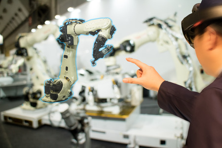 iot industry 4.0 concept,industrial engineer(blurred) using smart glasses with augmented mixed with virtual reality technology to monitoring machine in real time.Smart factory use Automation robot armの写真素材