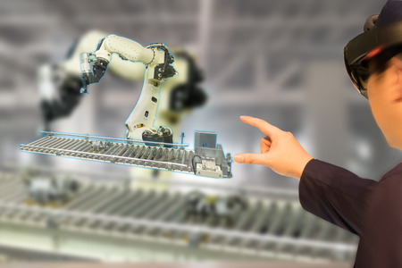 iot industry 4.0 concept,industrial engineer(blurred) using smart glasses with augmented mixed with virtual reality technology to monitoring machine in real time.Smart factory use Automation robot armの写真素材