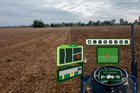 iot smart industry robot 4.0 agriculture concept,industrial agronomist,farmer using autonomous tractor with self driving technology , augmented mixed virtual reality to collect, access, analyze soilの写真素材