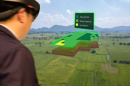 iot smart industry 4.0 agriculture concept,agronomist,farmer(blurred) using smart glasses (augmented mixed virtual reality,artificial intelligence technology) to track, keep, collect about farm in 3dの写真素材