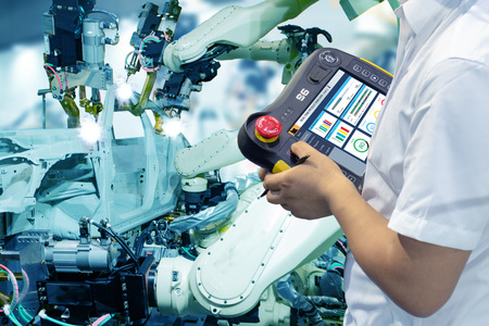iot smart factory , industry 4.0 technology concept, Engineer use controller robot in automation factory background with fake sunlight on operation line, Futuristic in the new trend technologyの写真素材