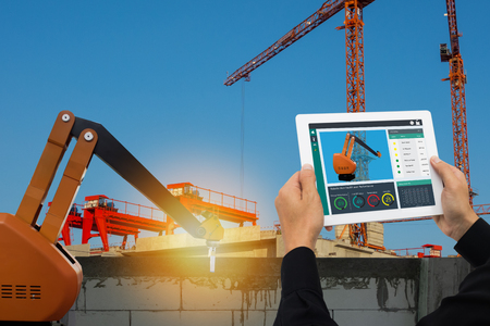 iot smart factory , industry 4.0 technology concept, Engineer use tablet to monitor, detect and analysis the robot arm for construction filed, Robot arm use to lay brick and plaster wall or factoryの写真素材