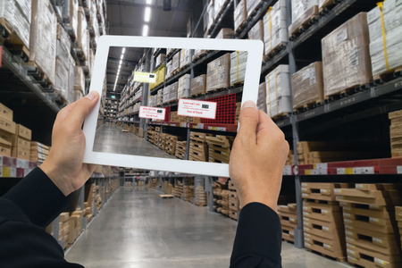 iot smart retail in the futuristic concept, the retailer hold the tablet and use augmented reality technology monitor data of out of shelve, price, planogram, campaign of compliance in the real timeの写真素材
