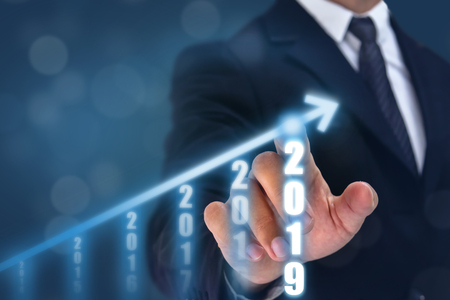 business man point hand on the top of arrow graph with high rate of growth. The success and growing growth graph in the company or industrial after investment in 2019の写真素材