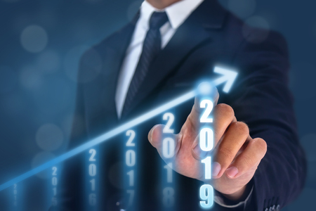 business man point hand on the top of arrow graph with high rate of growth. The success and growing growth graph in the company or industrial after investment in 2019の写真素材