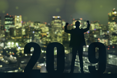celebrating new year 2019 Silhouette freedom young hope business man standing and enjoying on the the top of the building, city scape, landscape and 2019 years , copy spaceの写真素材
