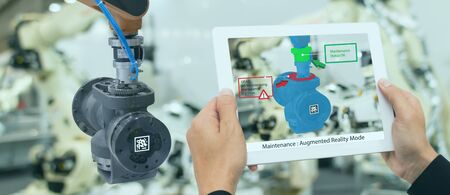 iot industry 4.0 concept,industrial engineer using smart tablet with augmented mixed with virtual reality technology to monitoring machine in real time.Smart factory use Automation robot armの写真素材