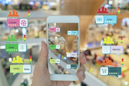 internet of things marketing concepts,smart augmented reality,customer hold the mobile phone to see  the shop type that search by ai application and predict the amount of people in that area near shopの写真素材