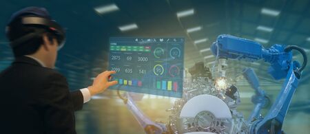 iot industry 4.0 concept,industrial engineer(blurred) using smart glasses with augmented mixed with virtual reality technology to monitoring machine in real time.Smart factory use Automation robot armの写真素材