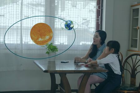 smart learning with augmented mixed virtual reality technology education concept, mother try to teach daughter by using artificial intelligence in subject in math, Science for creation, interaction,の写真素材