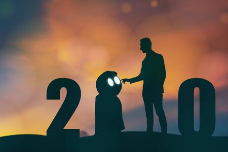 2020 year artificial intelligence or ai futuristic concept, Silhouette  Business man stand and point hand to command or control assistant robot, industry 4.0 trend of automation robot in 2020 futureの写真素材