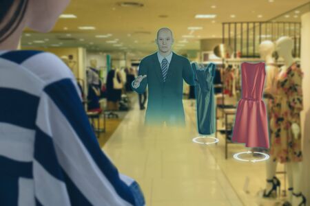 iot smart retail futuristic technology concept, happy girl try to use smart display with virtual or augmented reality  in the shop or retail to choose select ,buy cloths and give a rating of productsの写真素材