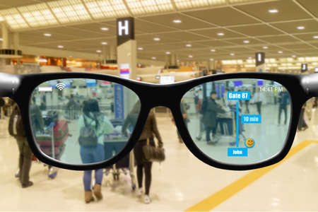 Futuristic technology trend concept in smart glasses.user use smart glasses with augmented mixed virtual reality while go to airport to get data check in boarding take off time gate numberの写真素材