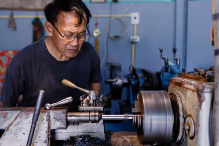 Asians Craftsman being machined steel in a factory.の写真素材
