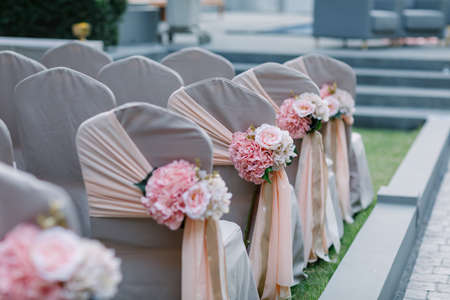 Wedding chairs decorated with bouquets of flowers.の写真素材