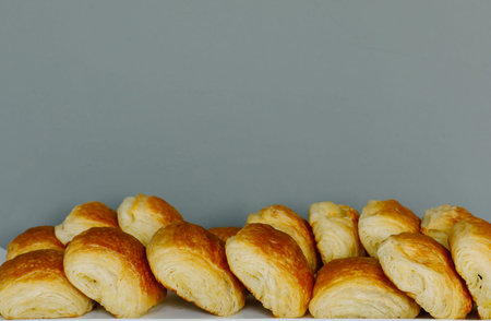 Many breads are placed in a tray with a gray background.の写真素材