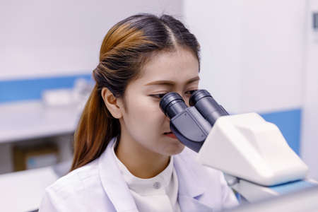 Scientist using a microscope in a laboratoryの写真素材