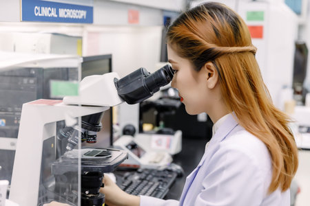 Scientist using a microscope in a laboratoryの写真素材